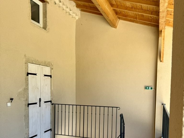 Le palier extérieur du gîte à l'étage, charpente apparente et ferronnerie