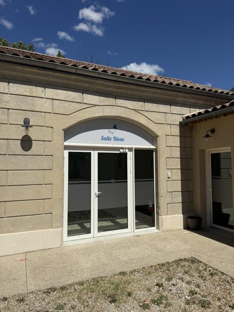 L'entrée en pierre de la Salle Bleue et sa porte vitrée